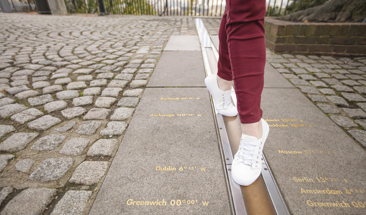 A woman's feet tip-toeing on the Meridian Line at the Royal Observatory in Greenwich.